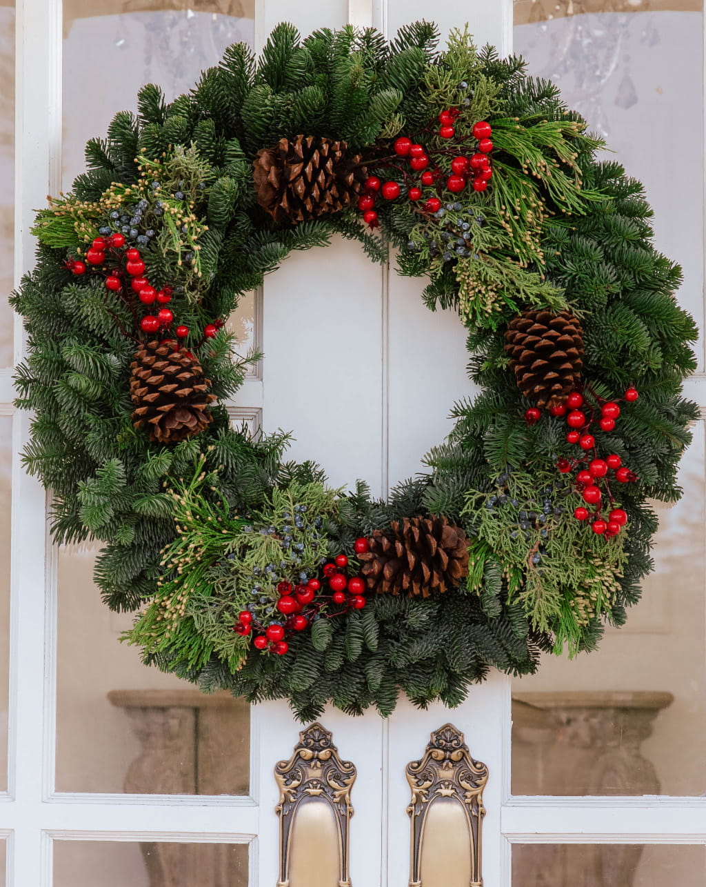 Traditional wreath with red crab apples fresh greenery available in 20 to 26 inch sizes for Christmas decor and holiday wreath display